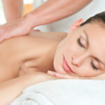 Beautiful young woman relaxing with hand massage at beauty spa